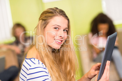 Casual young woman using digital tablet in office