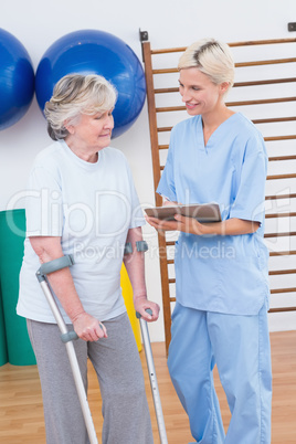 Therapist and senior woman looking at clipboard