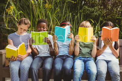 Children reading books at park