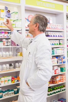 Pharmacist taking medicine from shelf