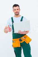 Smiling construction worker holding laptop