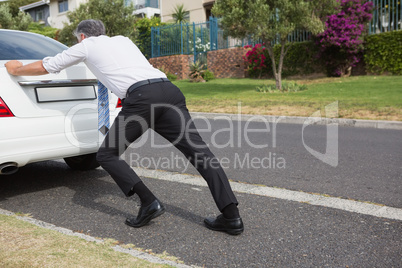 Man pushing his broken down car