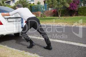 Man pushing his broken down car