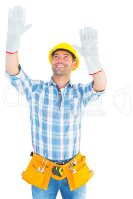 Manual worker raising hands while looking up