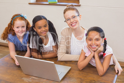 Teacher and pupils looking at laptop