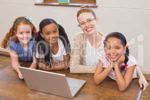 Teacher and pupils looking at laptop