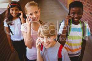 School kids using cellphones in school corridor