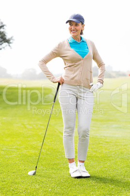 Female golfer standing with hand on hip
