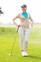 Female golfer standing with hand on hip