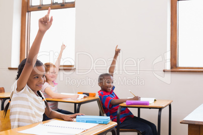 Pupils raising their hands during class