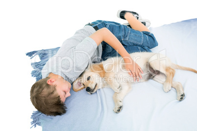 Boy lying with puppy on blanket over white background
