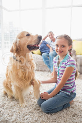 Portrait of happy girl playing with dog at home