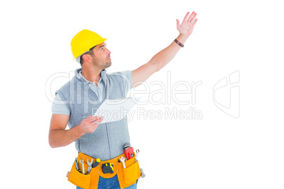 Male supervisor with hand raised holding clipboard