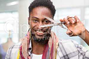 Happy male fashion designer holding scissors