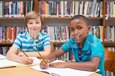 Cute pupils drawing in library