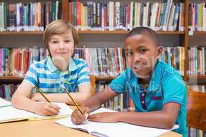 Cute pupils drawing in library