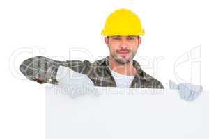 Handyman holding and pointing at blank board