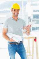 Smiling architect with blueprints and clipboard in office
