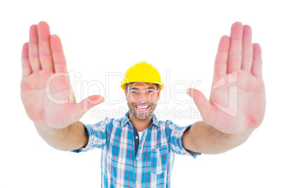 Smiling manual worker gesturing stop sign