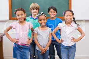 Cute pupils smiling at camera in classroom