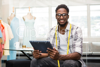 Confident male fashion designer with digital tablet
