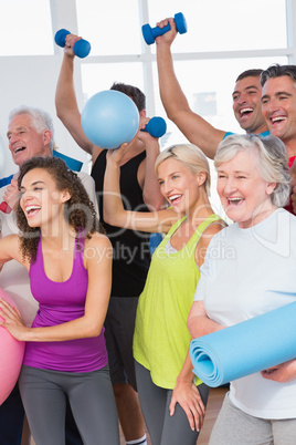 Cheerful friends with hands raised holding equipment