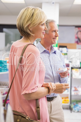 Smiling couple standing with medication