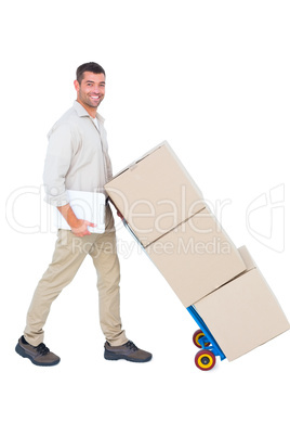 Happy delivery man pushing trolley of boxes Happy delivery man pushing trolley of boxes