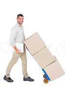 Happy delivery man pushing trolley of boxes