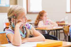 Thoughtful pupil sitting at her desk