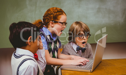 Shocked little school kids using laptop