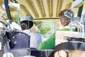 Golfing friends driving in their golf buggy