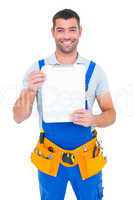 Portrait of happy repairman showing blank clipboard
