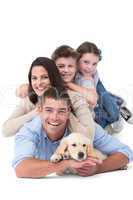 Happy family lying on top of each other with dog
