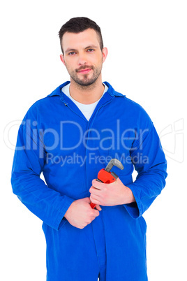 Smiling male mechanic holding monkey wrench