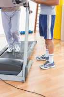 Senior man on treadmill with trainer