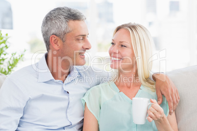Woman holding coffee cup while looking at man
