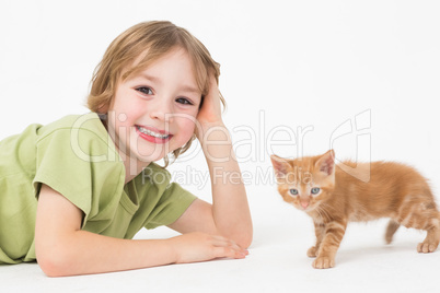 Portrait of smiling boy lying by kitten