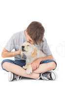 Boy kissing puppy over white background