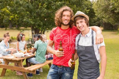 Happy friends in the park having barbecue