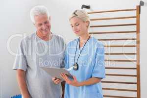 Therapist showing clipboard to senior man