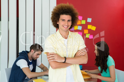 Casual young man with arms crossed in office