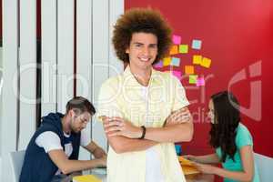 Casual young man with arms crossed in office