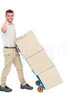 Delivery man with cardboard boxes gesturing thumbs up