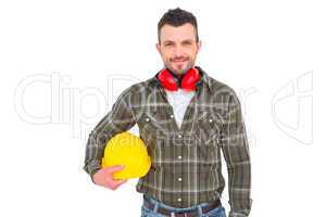 Handyman with earmuffs holding helmet