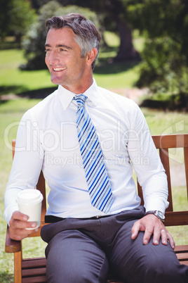Businessman having coffee in the park