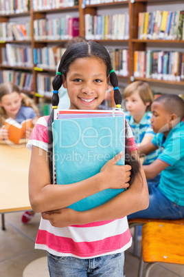 Cute pupil smiling at camera in library