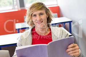 Male student reading notes in classroom
