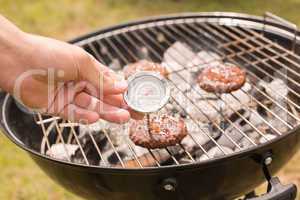 Man using meat thermometer while barbecuing