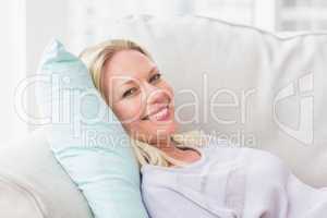 Portrait of happy woman lying on sofa